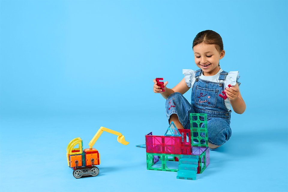 A girl playing with Chad Valley construction toys.